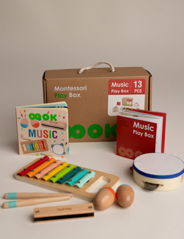 Montessori music play box with toys and books on a neutral background