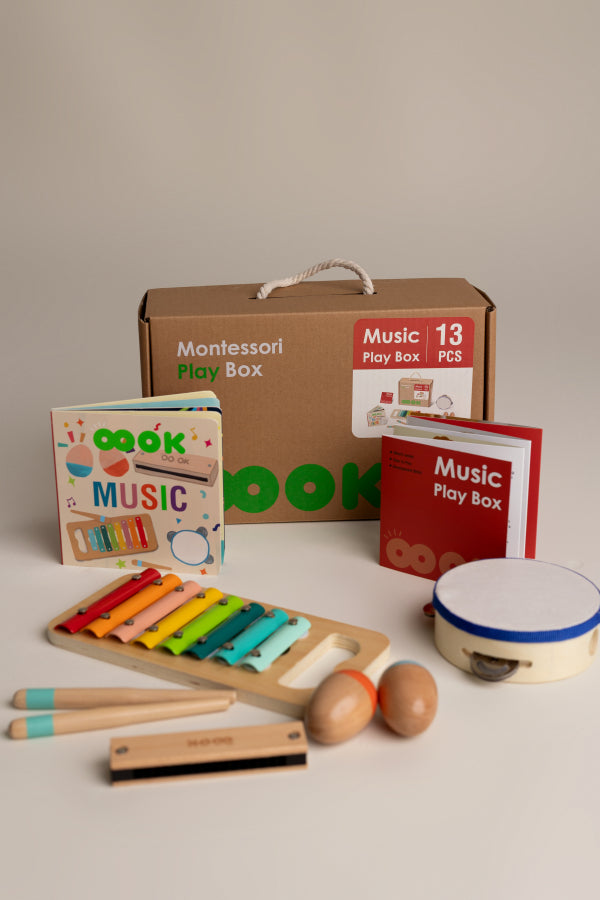 Montessori music play box with toys and books on a neutral background