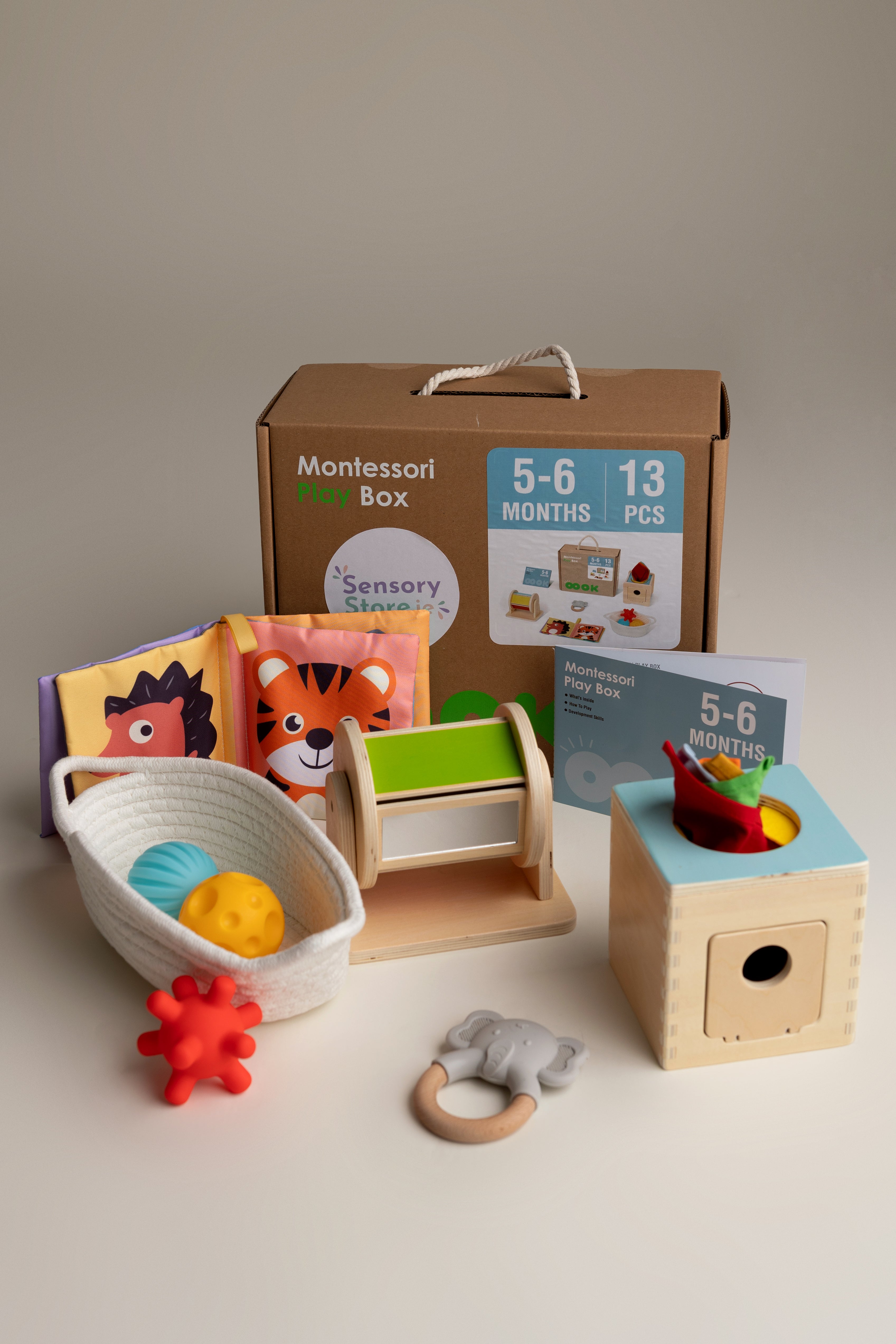 Collection of Montessori educational toys for a baby aged 5-6 months on a neutral background