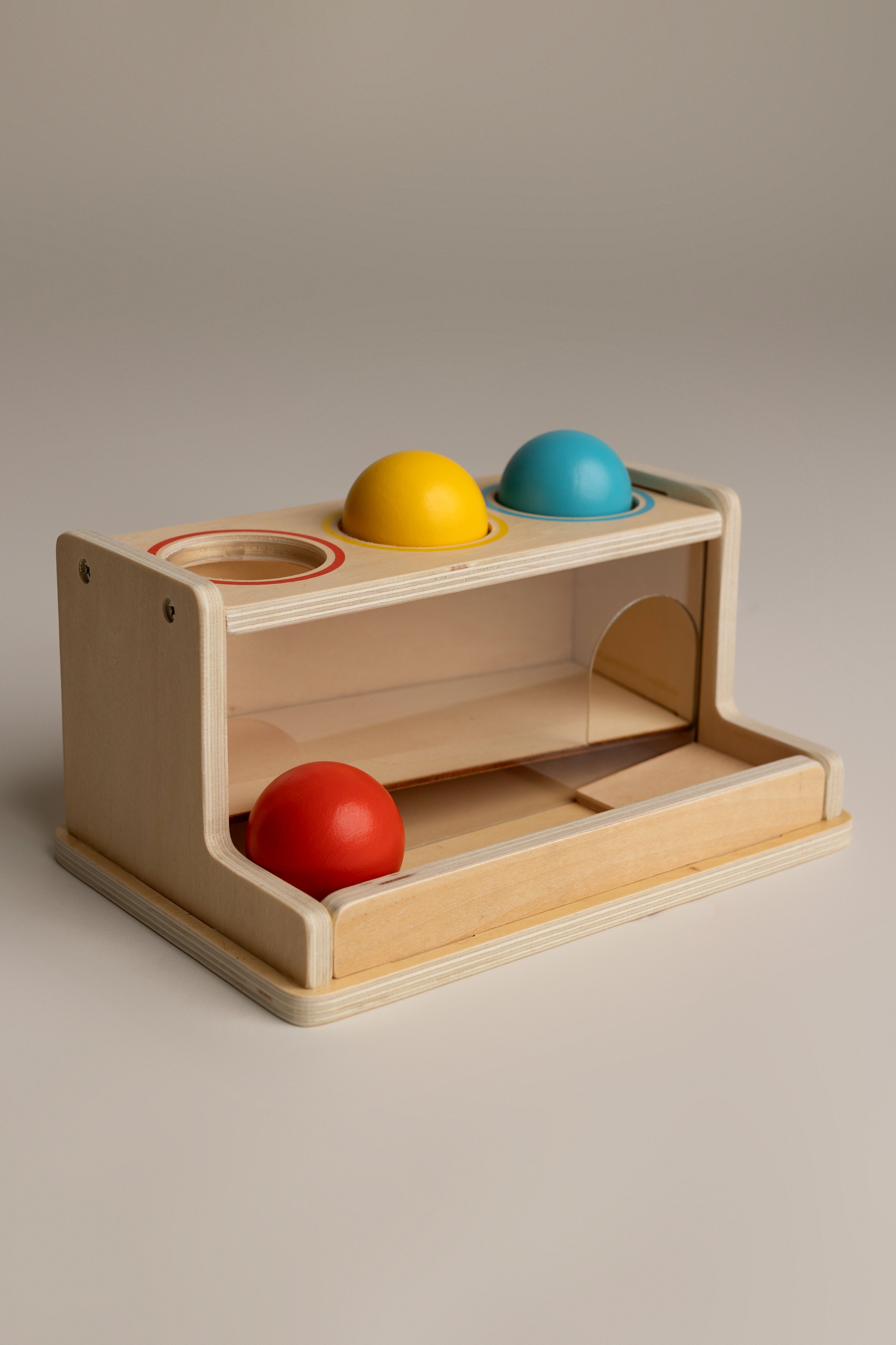 Wooden toy with colorful spheres on a neutral background