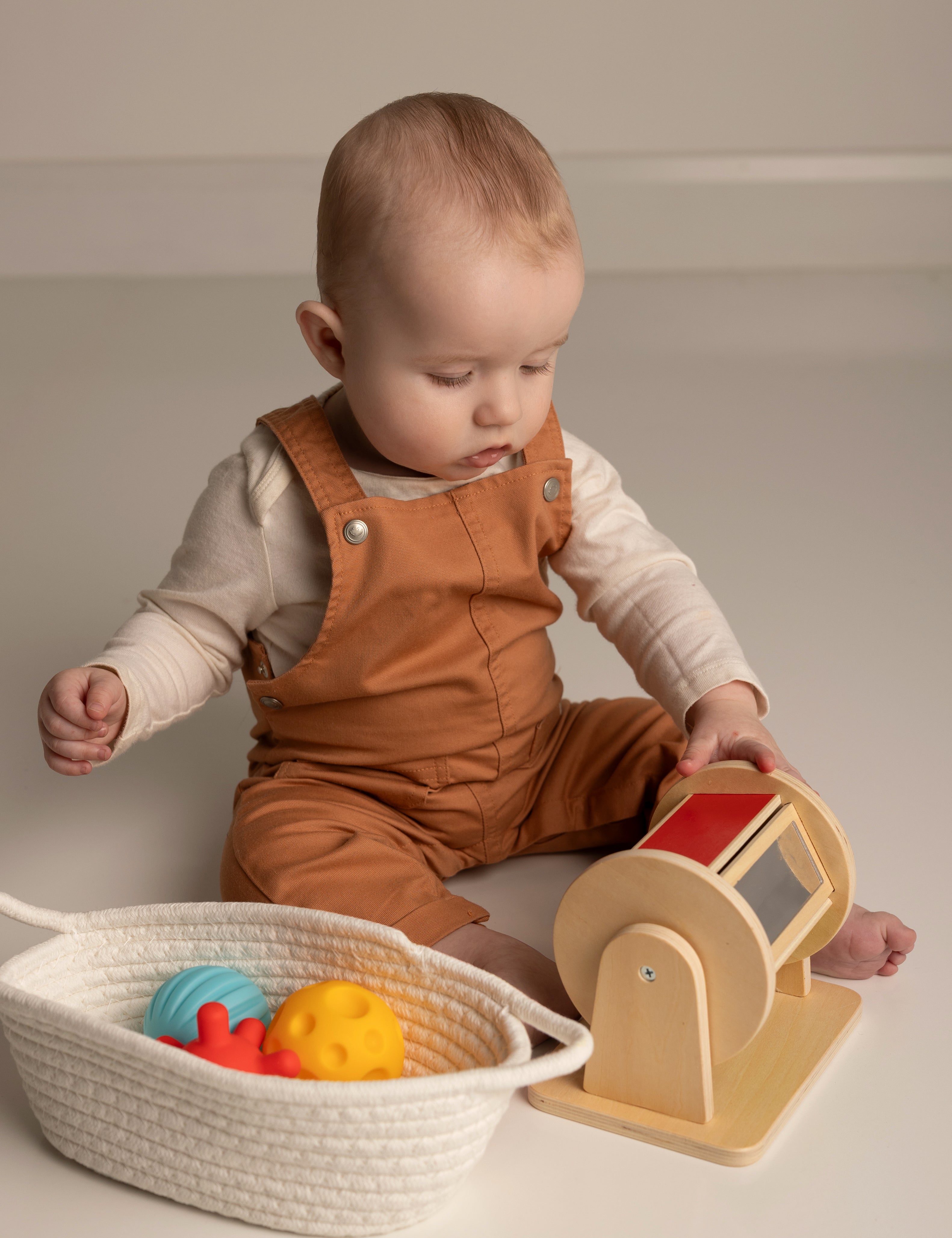 Baby playing with toys on a plain background
