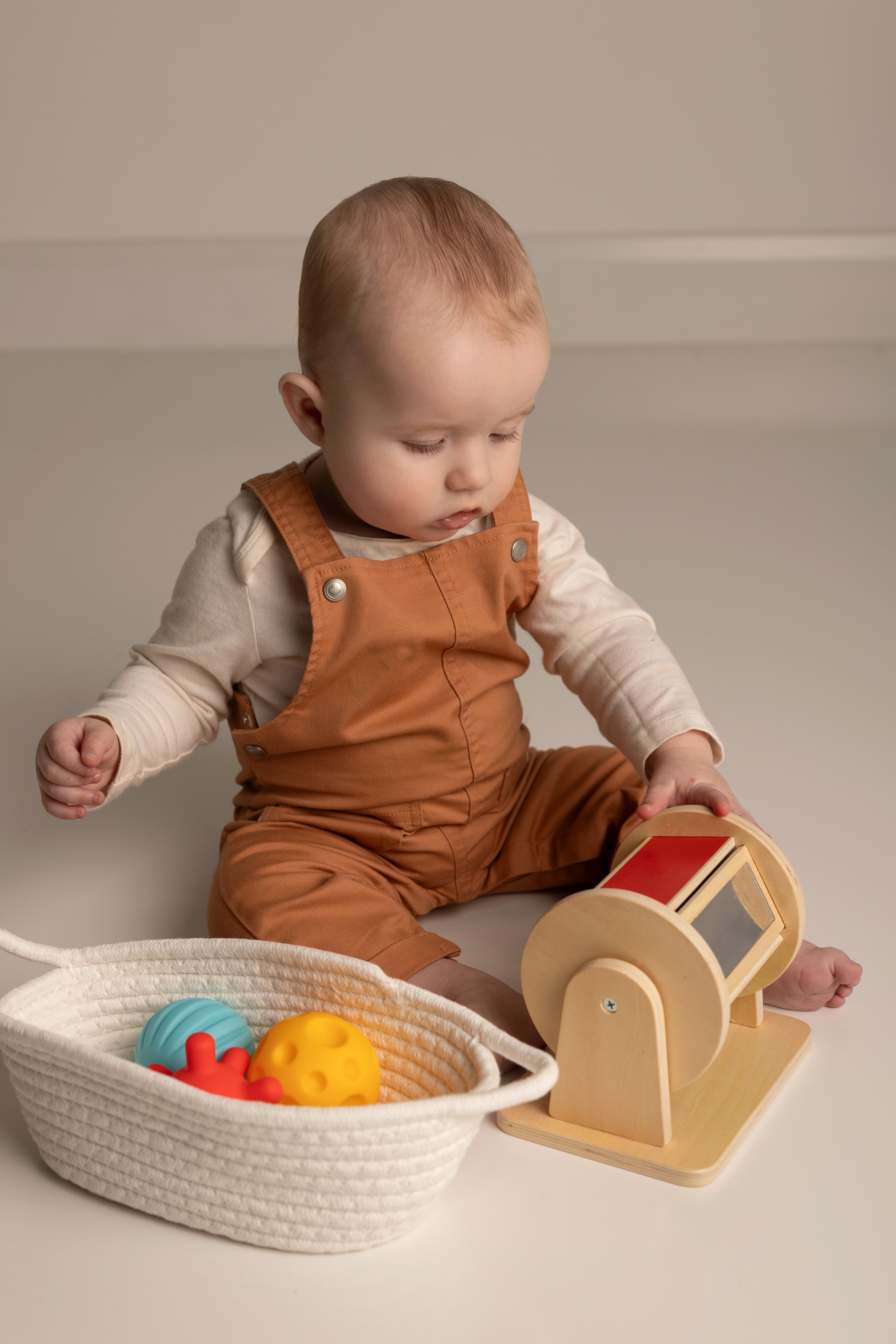 Baby playing with toys on a plain background