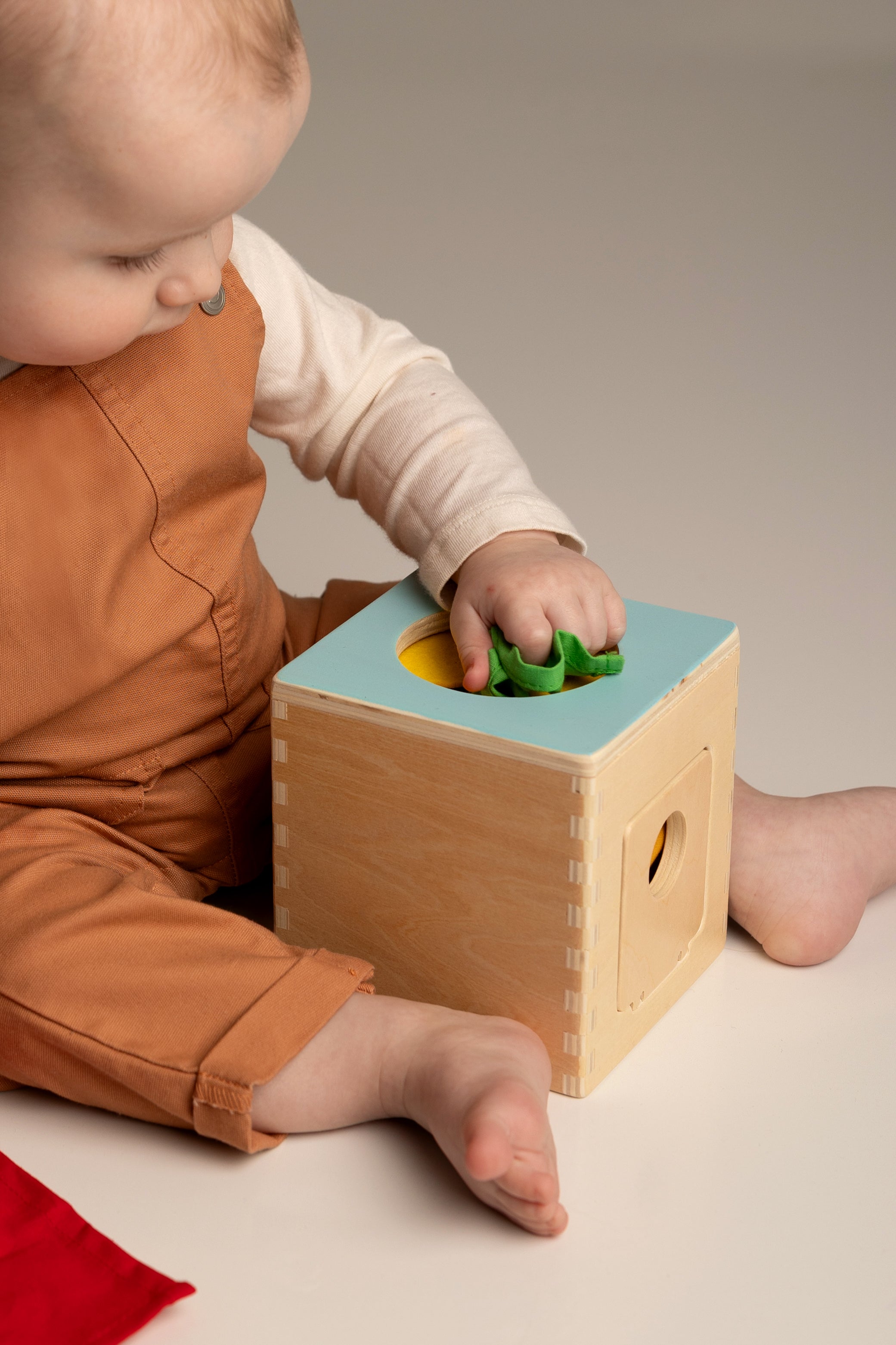 Child playing with a wooden shape sorter toy.