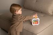 Child playing with a colorful toy on a beige couch