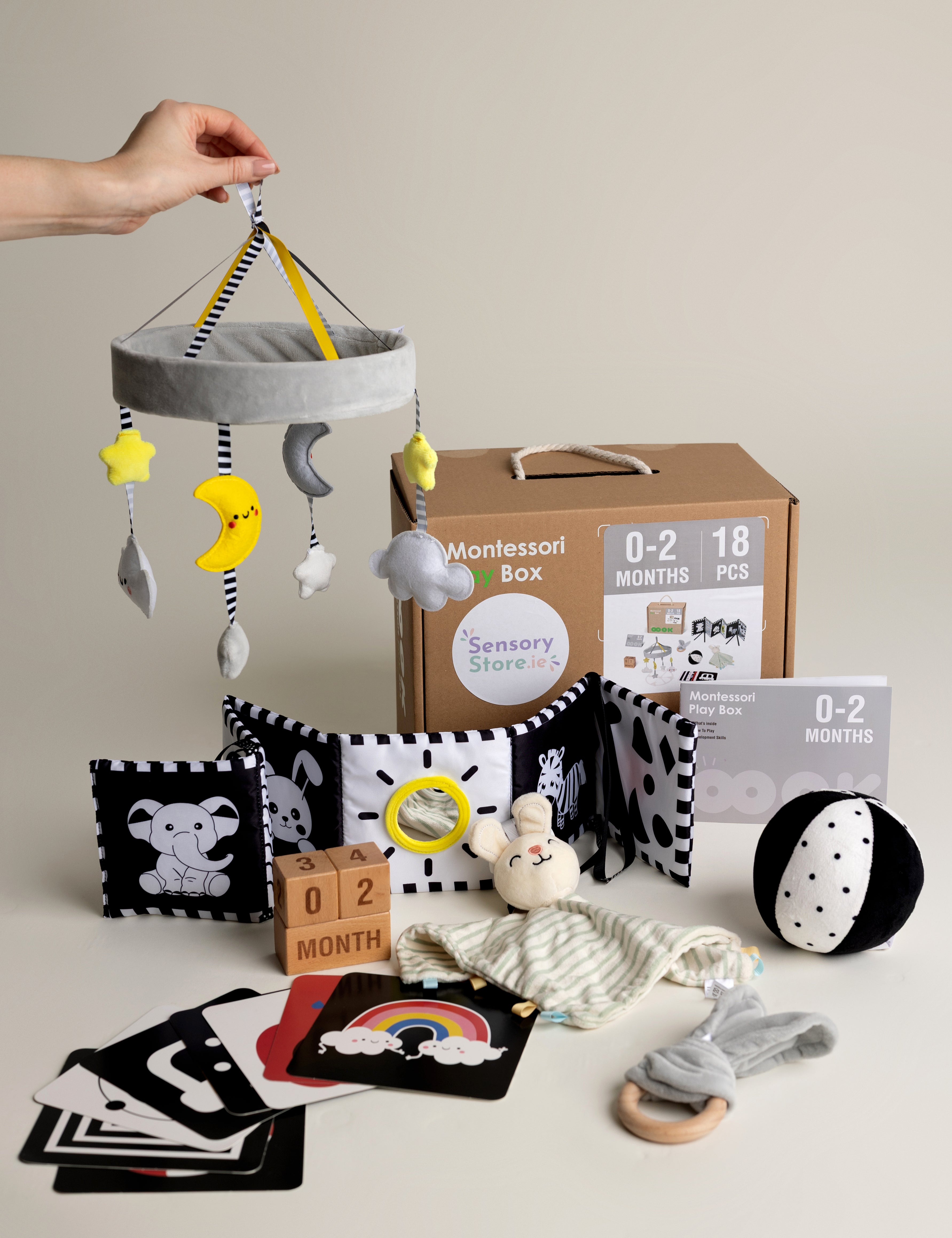 Newborn baby toys and educational items on a light surface with a neutral background